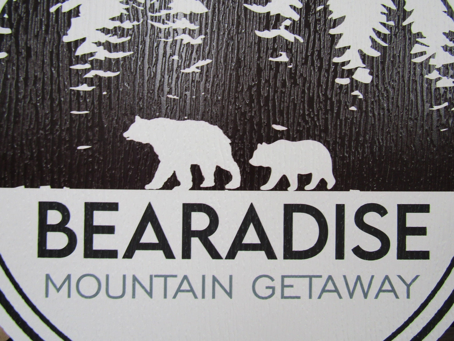 A close up of PVC sign for Bear's Paradise Mountain Getaway, featuring custom cabin pine trees wilderness bears textured PVC, weather fade resistant, waterproof UV printed color logo business commercial signage