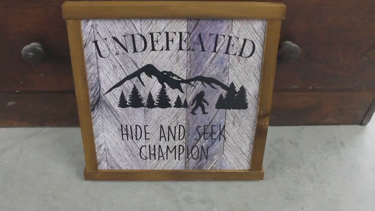 Printed Bigfoot Sign – Rustic Wood Framed Wall Art – Funny Sasquatch Cabin Decor – Undefeated Hide and Seek Champion Printed Wooden Sign